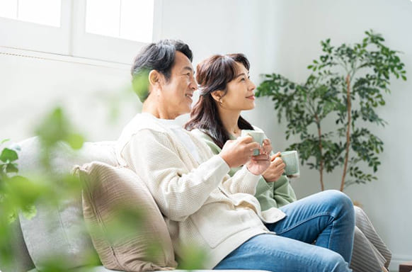 洗濯物を持ち窓辺に立つ女性