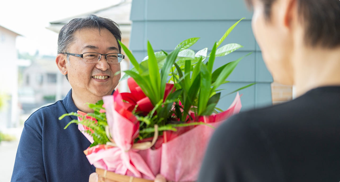 お客様に花束を手渡すスタッフ