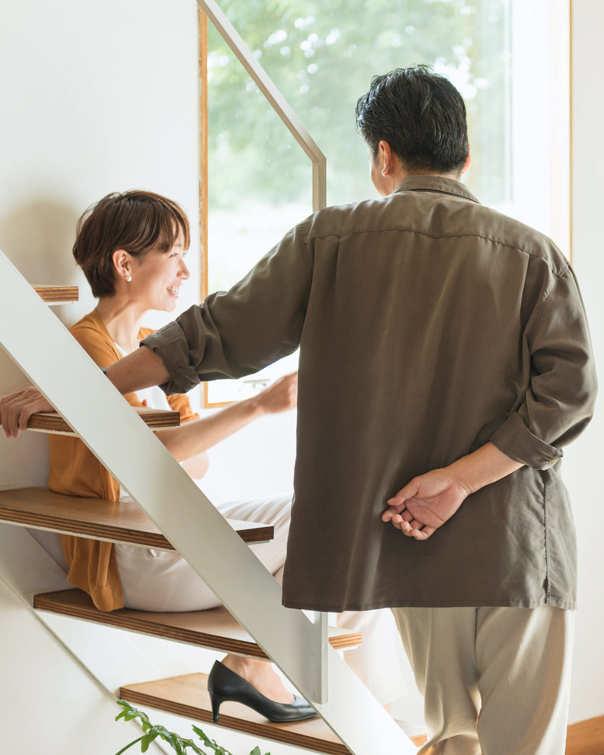 階段で会話する夫婦